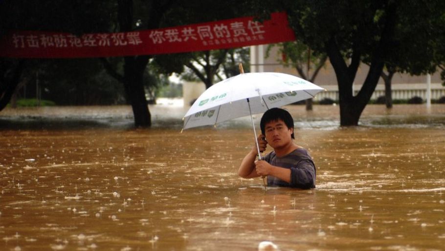 En mand kæmper sig gennem de vandplagede gader i den kinesiske Yuijang-provins. Millioner af mennesker er evakueret på grund af de kraftige regnskyl. (AP Photo/Xinhua, Zhou Mi)