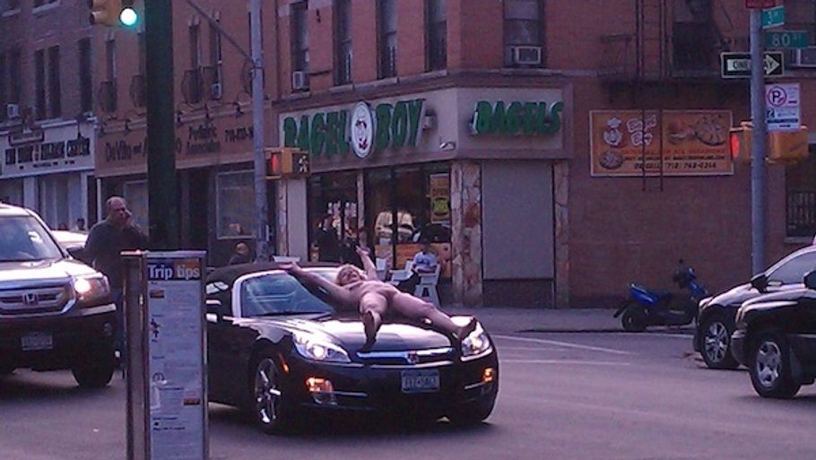 På et tidspunkt lægger den nøgne kvinde sig ovenpå køleren af en bil. Ingen griber ind. Alle tager billeder(foto: animalnewyork - anonymt øjenvidne)