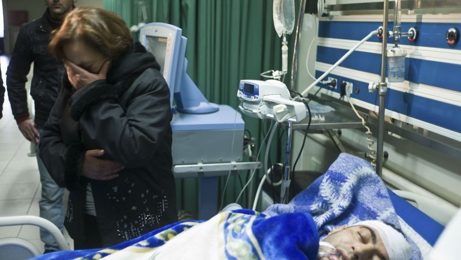 En syrisk kvinde græder for sin bevidstløse søn, der er kommet på hospitalet efter at være blevet angrebet. (Foto: Li Muzi/AP)