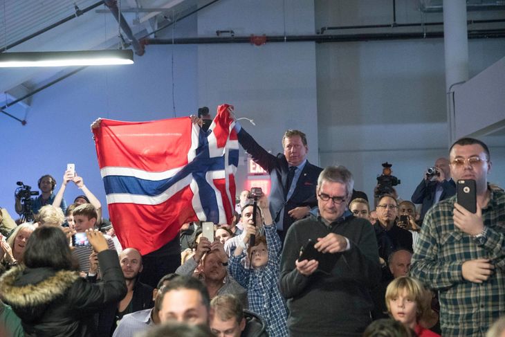 En tilskuer viser det norske flag til ære for skakmesteren Magnus Carlsen. (Foto: AP)