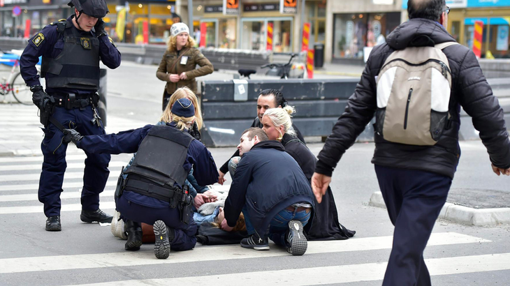 Tilfældige forbipasserende forsøger at hjælpe et af ofrene, kort efter lastbilen har passeret. Foto: Per Rasmussen