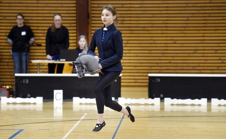 Elegant tøj skal der til, når den finske pige her og hesten springer af sted. Foto: AP