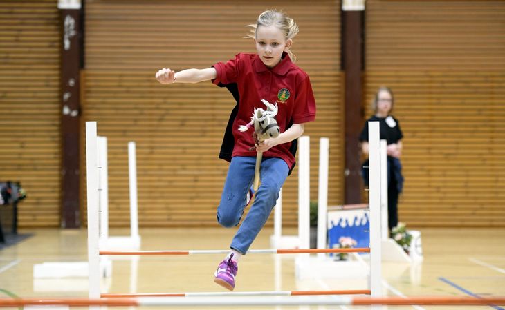 En pige er til konkurrence i kæpheste-springning i Finland. Foto: AP