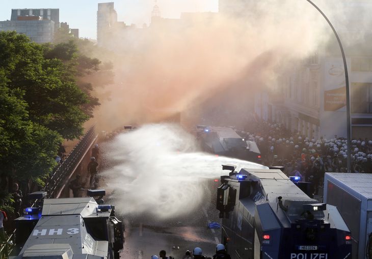 Her bruger politiet vandkanoner mod demonstranterne, da der opstod optøjer i gaderne. Foto: Michael Probst/AP