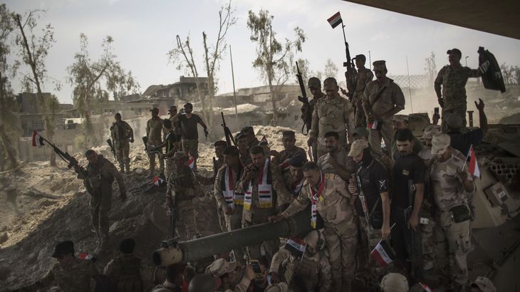 Irakiske soldater samles i eufori over sejren i Mosul. Foto: AP