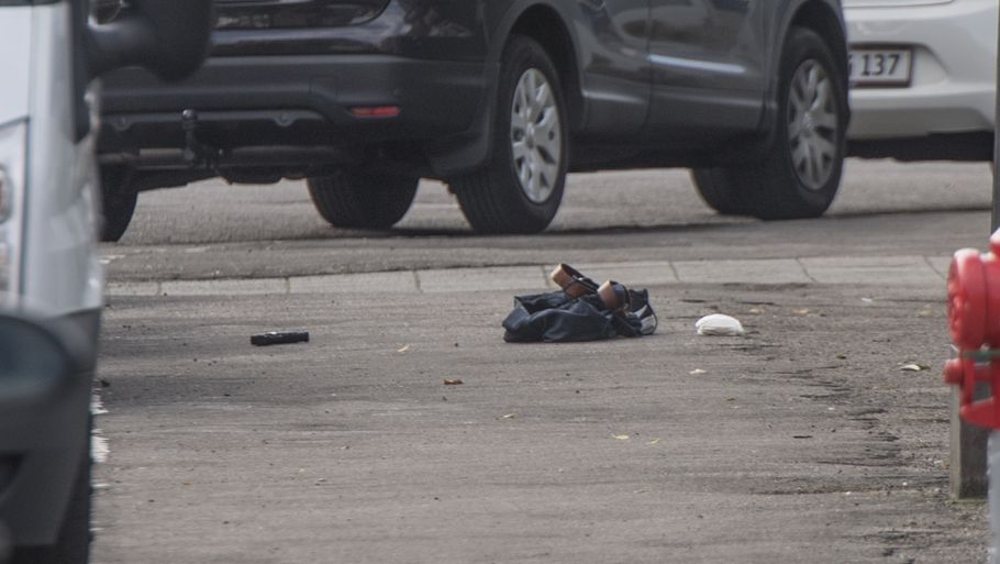 En pistol ligger på jorden ved siden af en taske. Foto: Anthon Unger