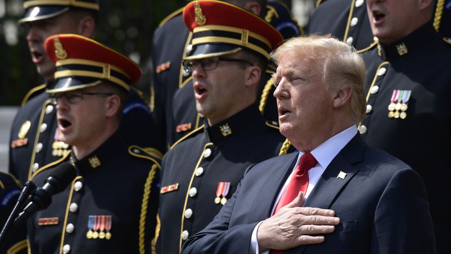 Sådan skal det gøres, mener den amerikanske præsident: Trump står op og synger med på nationalsangen. Foto: AP