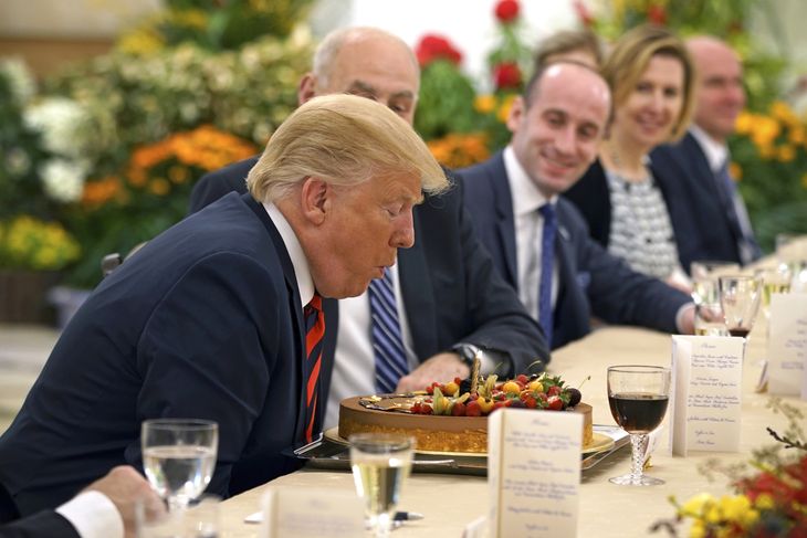 Donald Trump puster lysene på sin fødselsdagskage under middagen med Singapores premierminister. Den amerikanske præsident bliver 72 år 14. juni. Foto: AP 