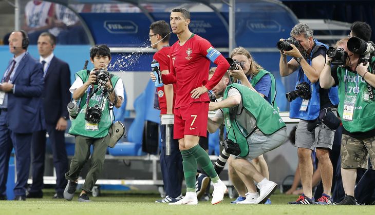 Crisitano Ronaldo spytter sin drik ud i kampen mod Portugal - det kan være 'carb rinsing' og ikke blot skyldes, at han vil skylle munden eller ikke kan lide drikken. Foto: AP