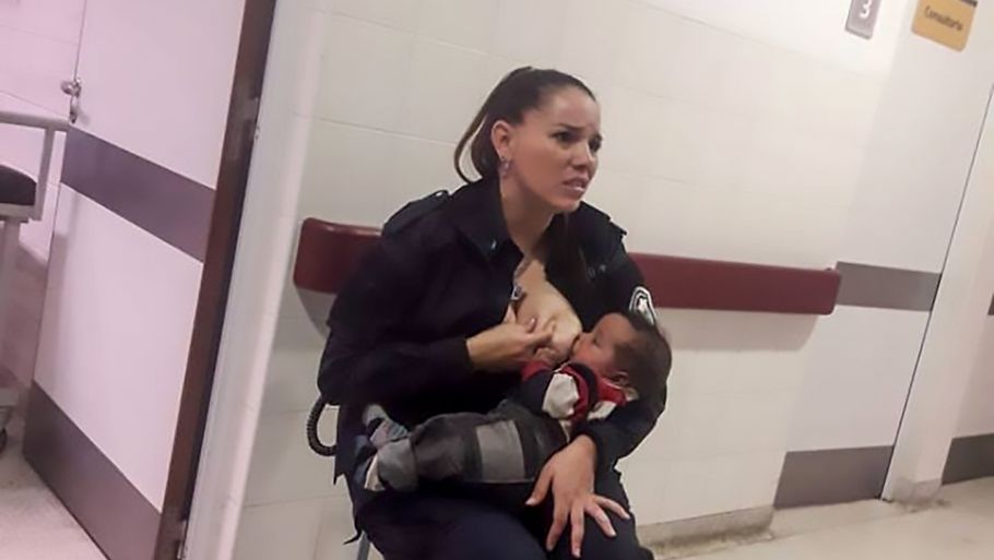 Politibetjenten Celeste Ayala får stor ros verden over for dette øjeblik, hvor hun tager brystet frem for at amme en 'beskidt' dreng. Foto: ALL OVER PRESS