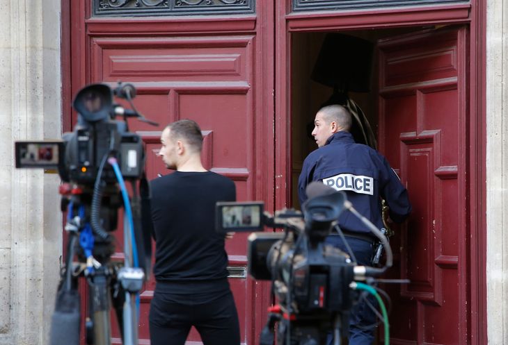 Fransk politi træder ind i lejligheden, hvor Kim Kardashian blev truet, røvet og bagbundet. Foto: Michel Euler/AP