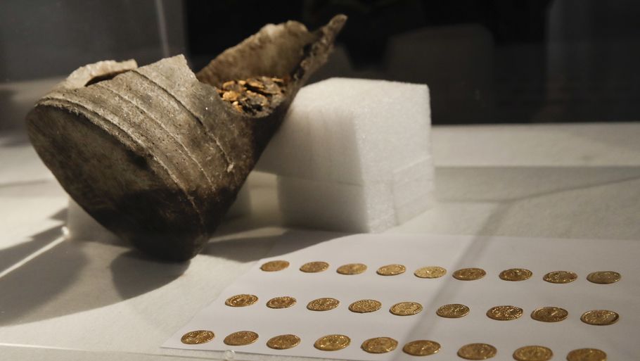 Her ses nogle af mønterne samt krukken, de blev fundet i. Fundet blev mandag vist frem på et pressemøde i den italienske by. Foto: Luca Bruno/AP