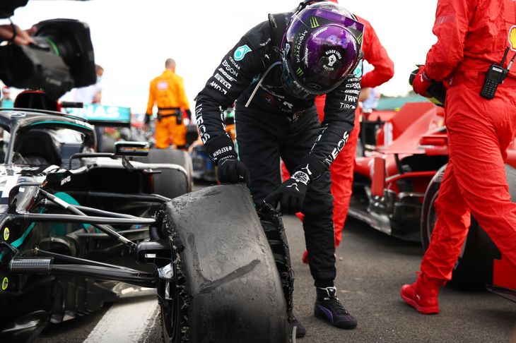 Lewis Hamilton besigtiger det punkterede forhjul, som var tæt på at koste ham sejren i søndagens Formel 1-grandprix på Silverstone. Foto: Bryn Lennon/Reuters