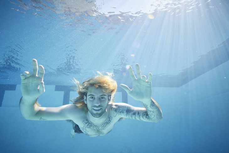 Spencer Elden i poolen som voksen - dog med badebukser på. På brystet har han en tatovering, hvor der står 'Nevermind'. Foto: SplashNews.com/Ritzau Scanpix