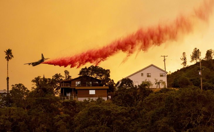 Et fly kaster flammehæmmende stof ned over hjemmene i Napa, Californien. Foto: Josh Edelson/Ritzau Scanpix
