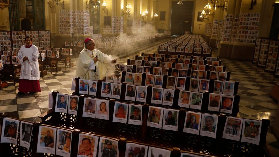 27.000 mennesker er døde under coronaepidemien i Peru. Bileder af ofrene har stået i Limas katedral i sommer og velsignes her af ærkebiskop Carlos Castillo. Nu føjes der mindt 13 indirekte ofre til efter en alvorlig ulykke på en natklub, der brød coronareglerne. Foto: Stringer/Reuters