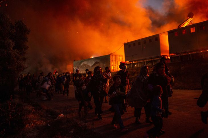 Foto: Migranter flygter fra flammerne. ANGELOS TZORTZINIS / AFP /Ritzau Scanpix