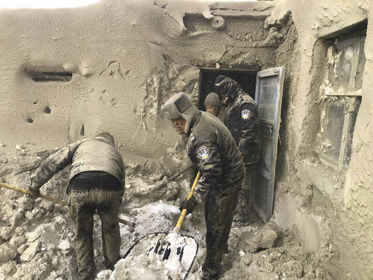 Politibetjente graver sig frem for at redde en 71-årig kvinde, som blev spærret inde under en voldsom sandstorm i det sydlige Mongoliet 15. marts. Foto: Ritzau Scanpix