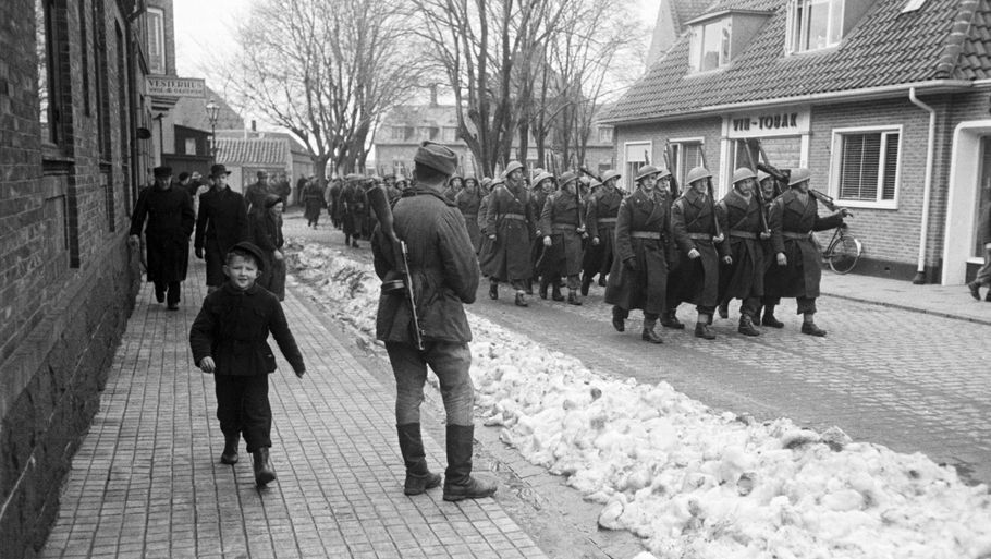 Midt i marts 1946 meddelte Sovjetunionen, at de ville forlade Bornholm. Her marcherer det første kompagni danske soldater gennem Rønnes gader, mens en russisk soldat ser på. Foto: Tage Christensen