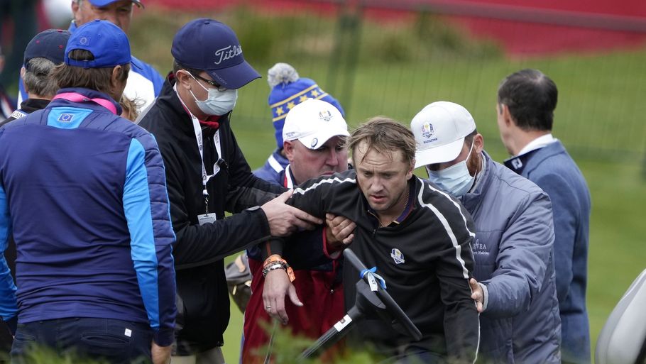 Skuespiller Tom Felton bliver hjulpet på benene efter at være kollapset på 18. hul af golfturnering. Foto: Ashley Landis/Ritzau Scanpix