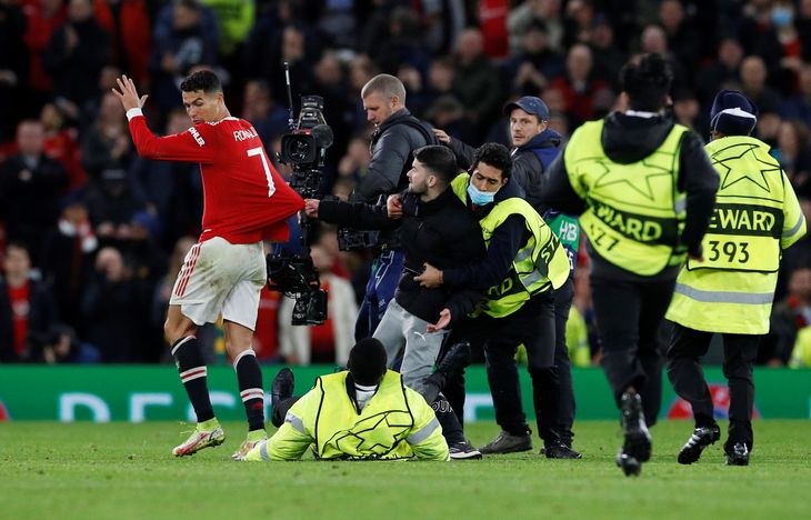 Cristiano Ronaldo fik sig noget af en overraskelse, da en baneløber fik fat i trøjen på ham. Foto: Phil Noble/Ritzau Scanpix