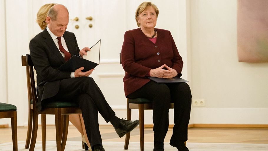 Tysklands finansminister og vicekansler, Olaf Scholz (t.v.), kigger på det officielle afskedscertifikat, han og regeringens øvrige ministre tirsdag fik overrakt af forbundspræsident Frank-Walter Steinmeier. Scholz ser lige nu ud til at være det mest sandsynlige bud på Tysklands næste forbundskansler efter den afgående, Angela Merkel (t.h.). Foto: Jens Schlueter/Ritzau Scanpix