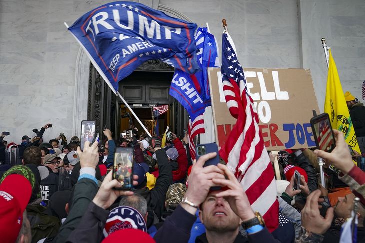 Med Trump-flag i hænderne og Trump-kasketter på hovedet indtog et stort antal mennesker USA's kongres 6. januar sidste år, da politikerne var i gang med den formelle godkendelse af Joe Bidens sejr ved præsidentvalget. Foto: John Minchillo/Ritzau Scanpix