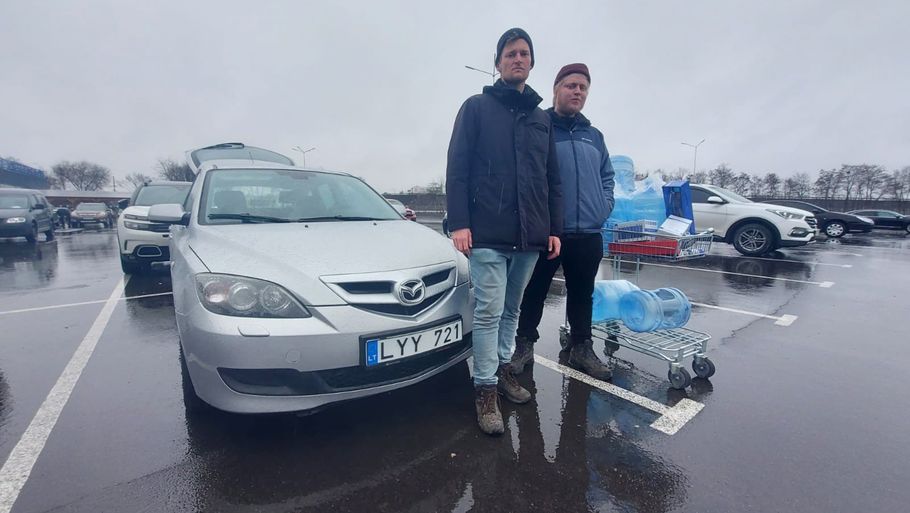Stefan Weichert (t.v.) og Emil Filtenborg foran deres bil, som de måtte tage flugten i, da de blev ramt af skud. Foto: Emil Filtenborg