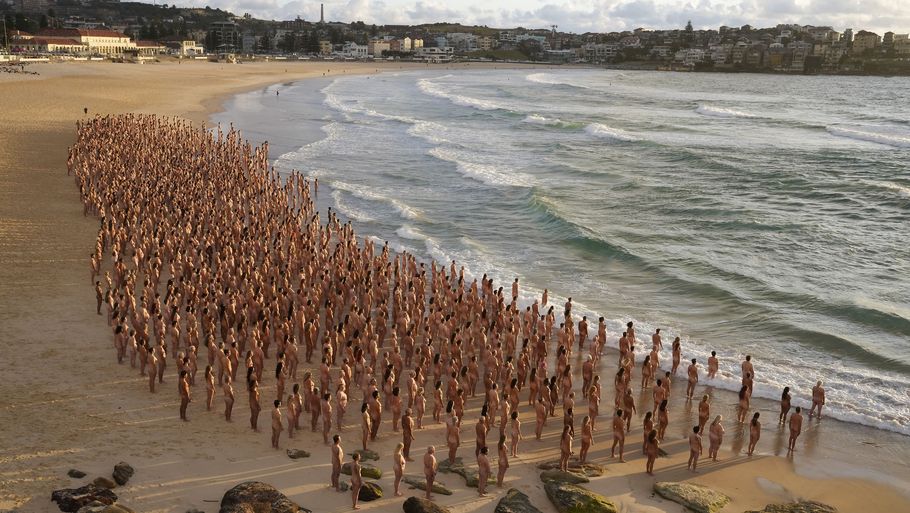 Kunstneren Spencer Tunick håber, at billederne af de mange nøgne mennesker på Bondi Beach kan være med til at minde australiere om jævnligt at blive tjekket for hudkræft. Foto: Rick Rycroft/Ritzau Scanpix