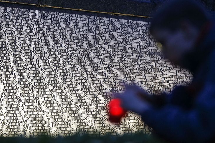 En dreng står foran et monument i Kyiv, hvorpå der står skrevet de steder, hvor folk døde under sultkatastrofen Holodomor. (Arkivfoto). Foto: Gleb Garanich/Reuters