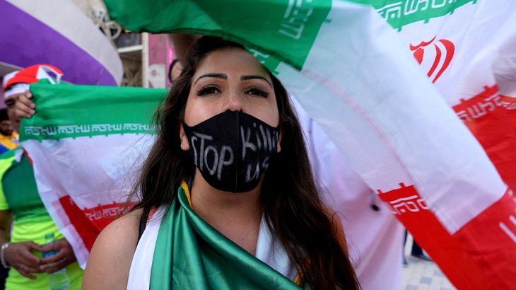 En iransk kvinde demonstrer med teksten 'stop killing us' efter kampen mellem Iran og Wales. Foto: Charlotte Bruneau/ REUTERS/ Ritzau Scanpix
