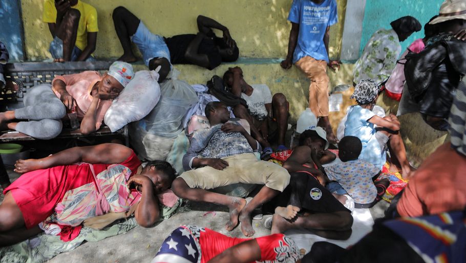 Indbyggere på flugt fra bander sover på gaden i bydelen Cite Soleil. Port-au-Prince ligger mellem grønne bjergsider og det blå Caribiske Hav. Men mange af de forarmede bydele er fyldt med affald i gaderne, som er dødsensfarlige at færdes i. Foto: Ralph Tedy Erol/Reuters