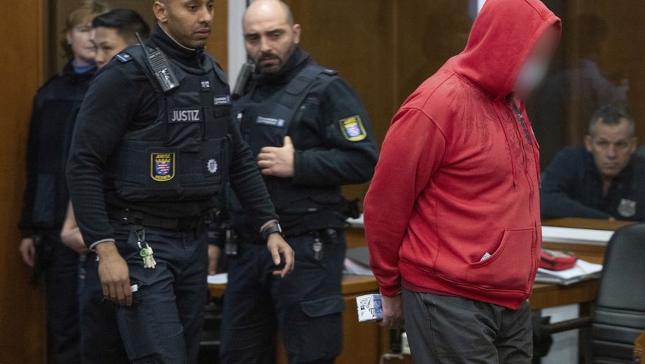 En af tiltalte føres ind i retten. Foto: Boris Roessler/picture-alliance/dpa/AP Images