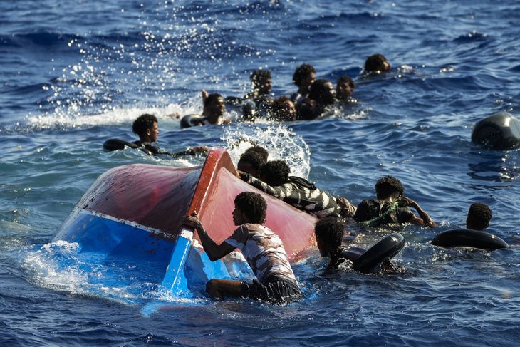 Migranter svømmer i vandet, efter at deres båd er kæntret ud for den italienske ø Lampedusa i august 2022. Foto: Francisco Seco/Ritzau Scanpix 