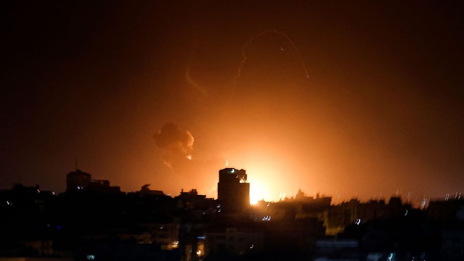 Ild og røg stiger op blandt bygninger i Gaza efter luftangreb fra det israelske militær. Foto: Mohammed Abed/Ritzau Scanpix