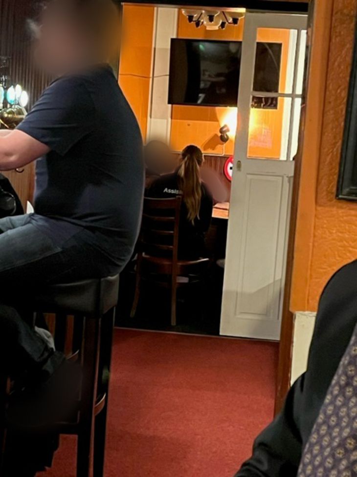 Kvinden i den sorte trøje med ryggen til er assistent i ambulancen. Her sidder hun i ikkeryger-delen af caféen, selvom det kun er en åben dør, der adskiller ryger- og ikkeryger-delen. Privatfoto