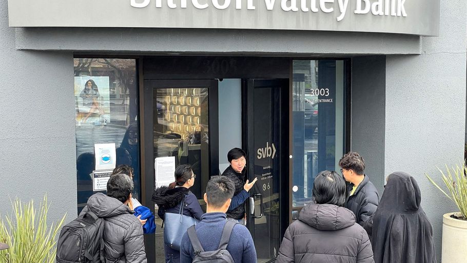 En ansat i Silicon Valley Banks hovedkontor i Californien fortæller kunder og andre personer, der er samlet uden for banken, at den var lukket fredag, efter at californiske myndigheder greb ind. Foto: Justin Sullivan/Ritzau Scanpix