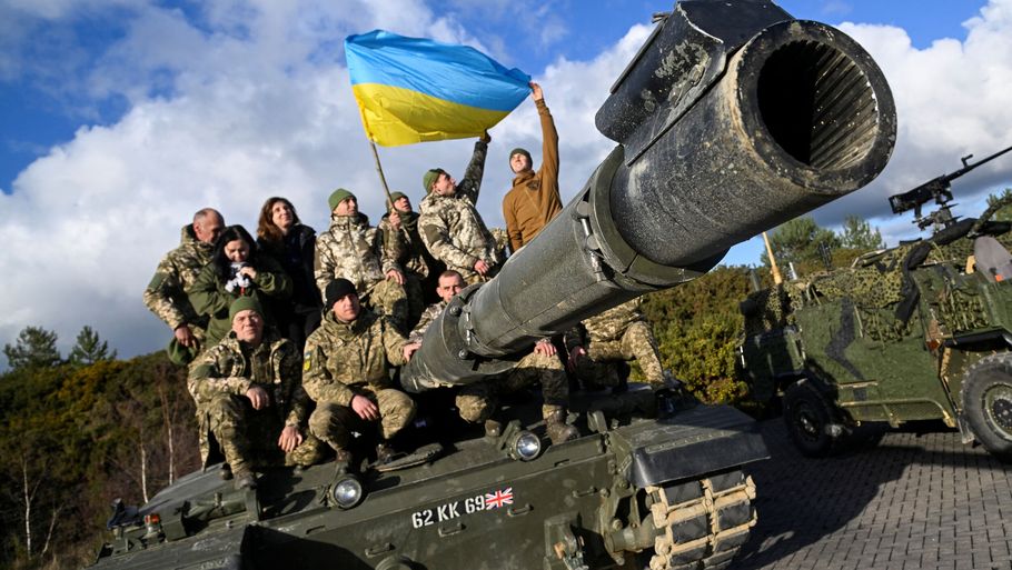 Ukrainske soldater poserede med det ukrainske flag, mens de befandt sig i Storbritannien. Her modtog de træning, så de kan betjene Challenger-kampvognene ved fronten. Foto: Toby Melville/Reuters